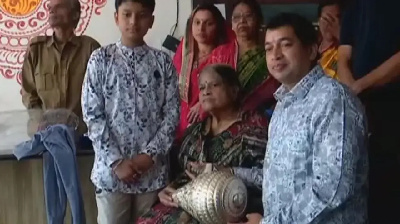 Devout gesture: Elderly woman offers silver conch to Lord Jagannath