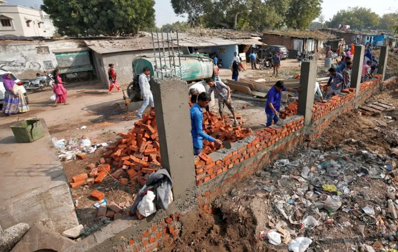 AMC Constructs Wall To cover Slum Ahead of Trump’s Visit