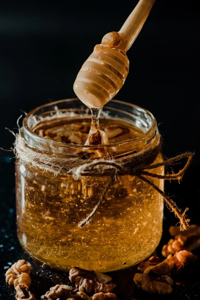 vertical-shot-of-honey-in-a-glass-jar-with-walnuts-2023-11-27-05-13-48-utc (1)