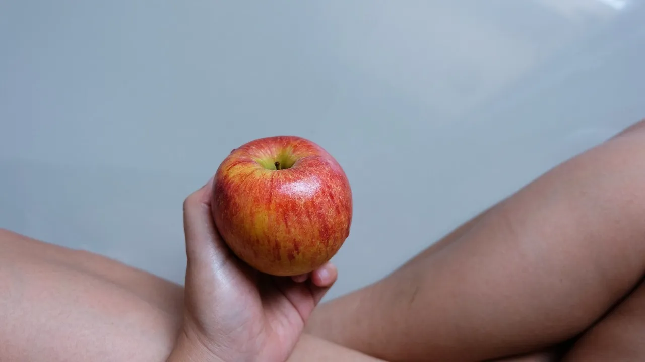Womans Hand Holding Red Apple