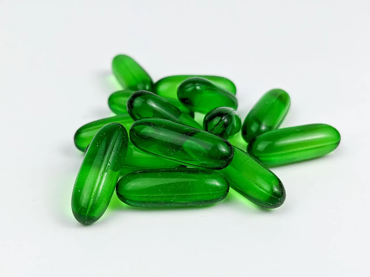 green-transparent-capsule-pills-of-vitamin-e-isolated-on-white-background-free-photo
