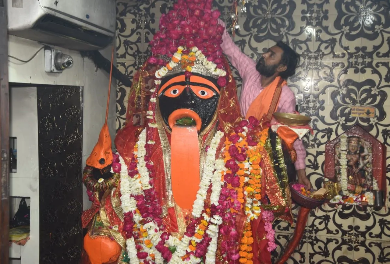 मां सतोषी की मूर्ति पर मंदिर के पुजारी जी फूल चढ़ाते हुए,