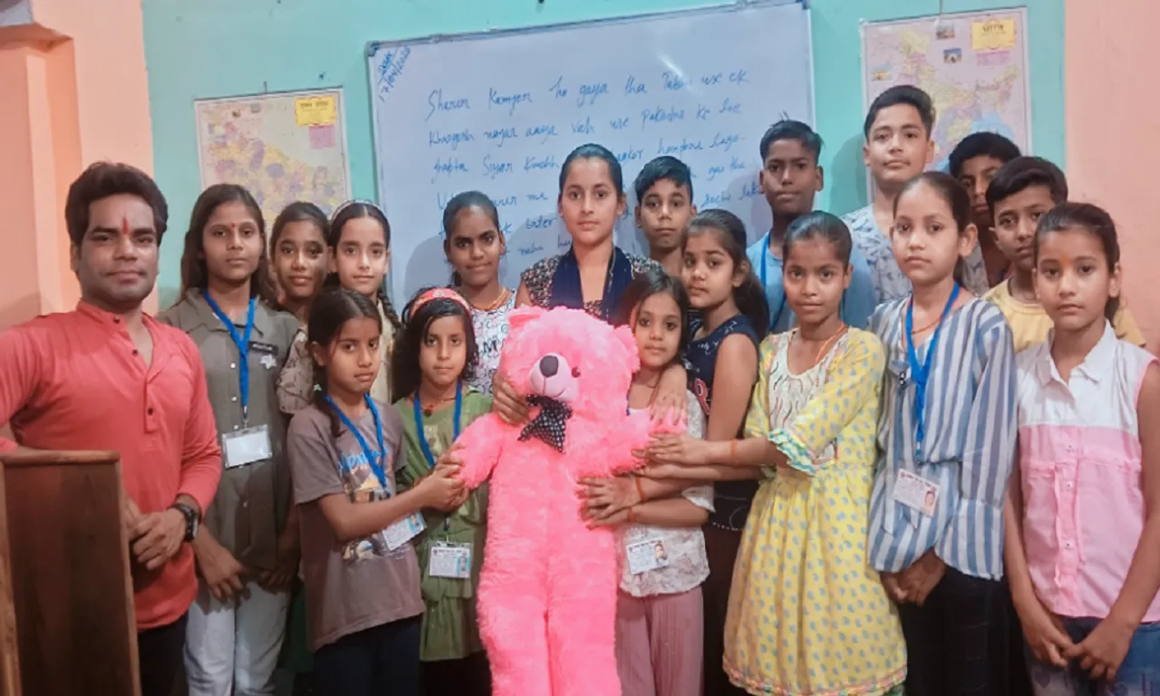 बच्चों सहायक अध्यापिका काजल को टेडी बियर करते 