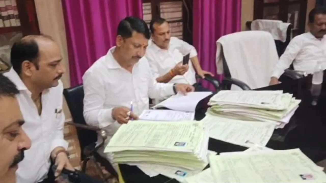 प्रपत्रों की जांच करते सदस्य।
