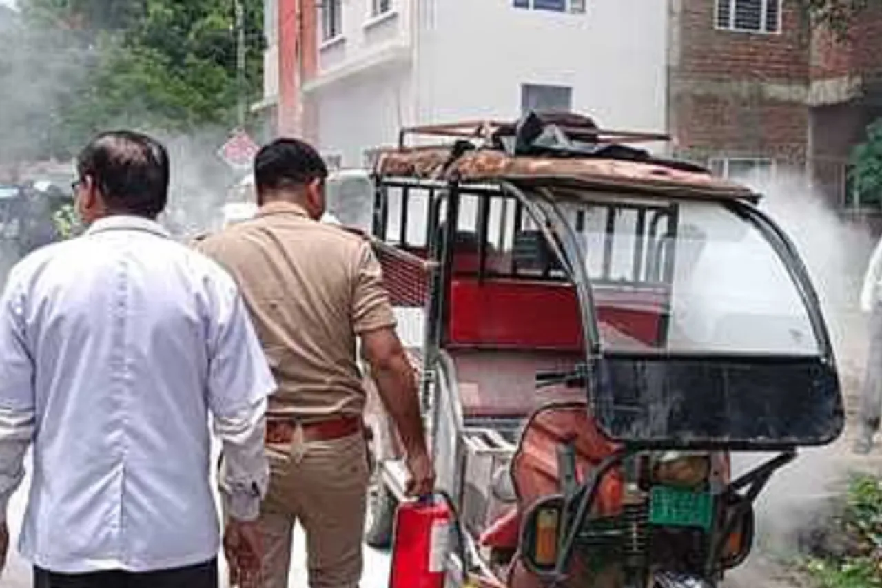 सिंजई में ई-रिक्शे में लगी आग को बुझाते दमकल कर्मी।