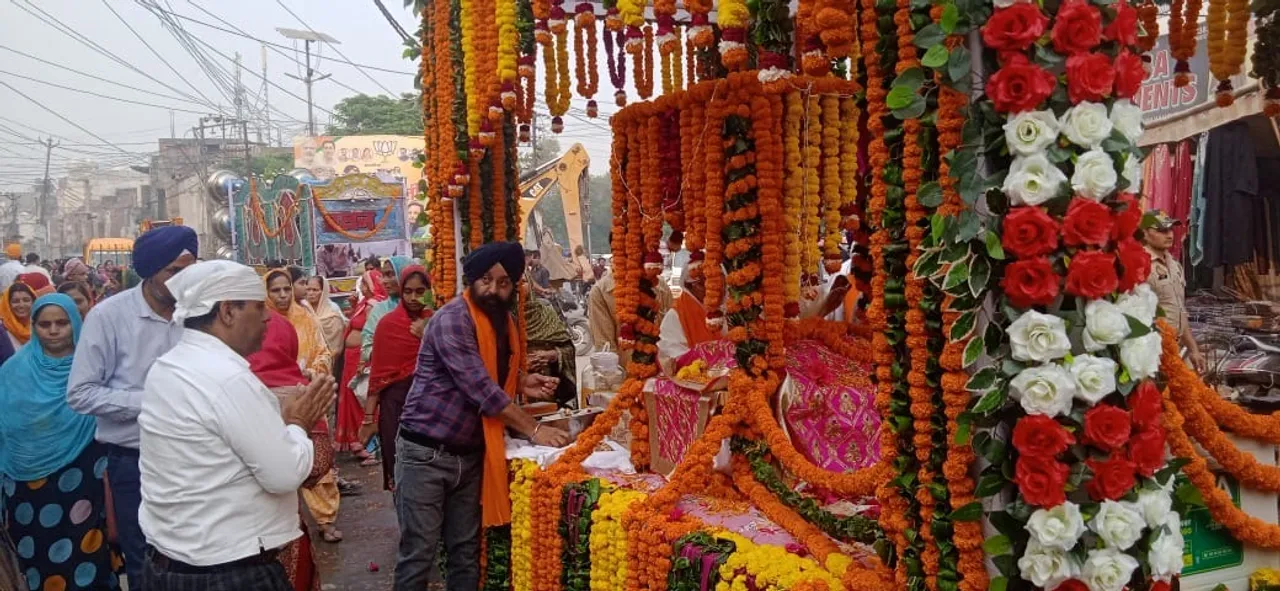 गुरुनानक देव जी के प्रकाशोत्सव के उपलक्ष्य में निकाले गए नगर कीर्तन  में गुरु ग्रंथ साहिब की पालकी के दर्शन करती संगत