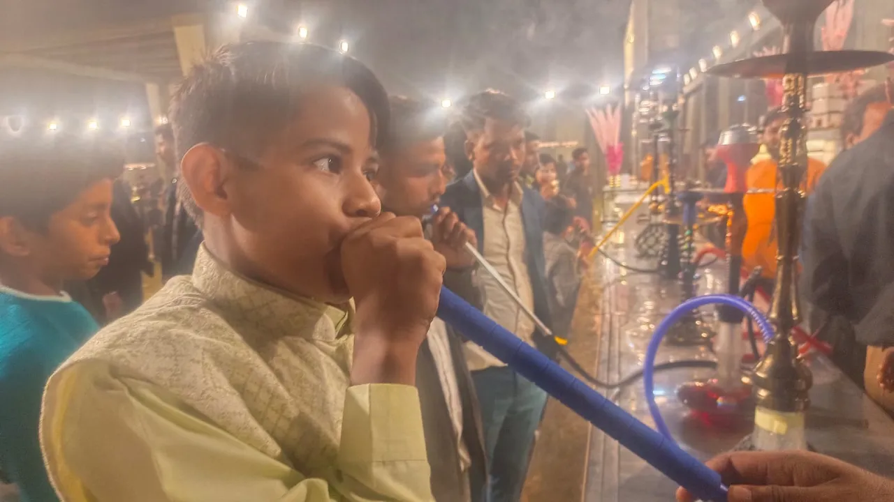एक विवाह समारोह में हुक्का पीता किशोर