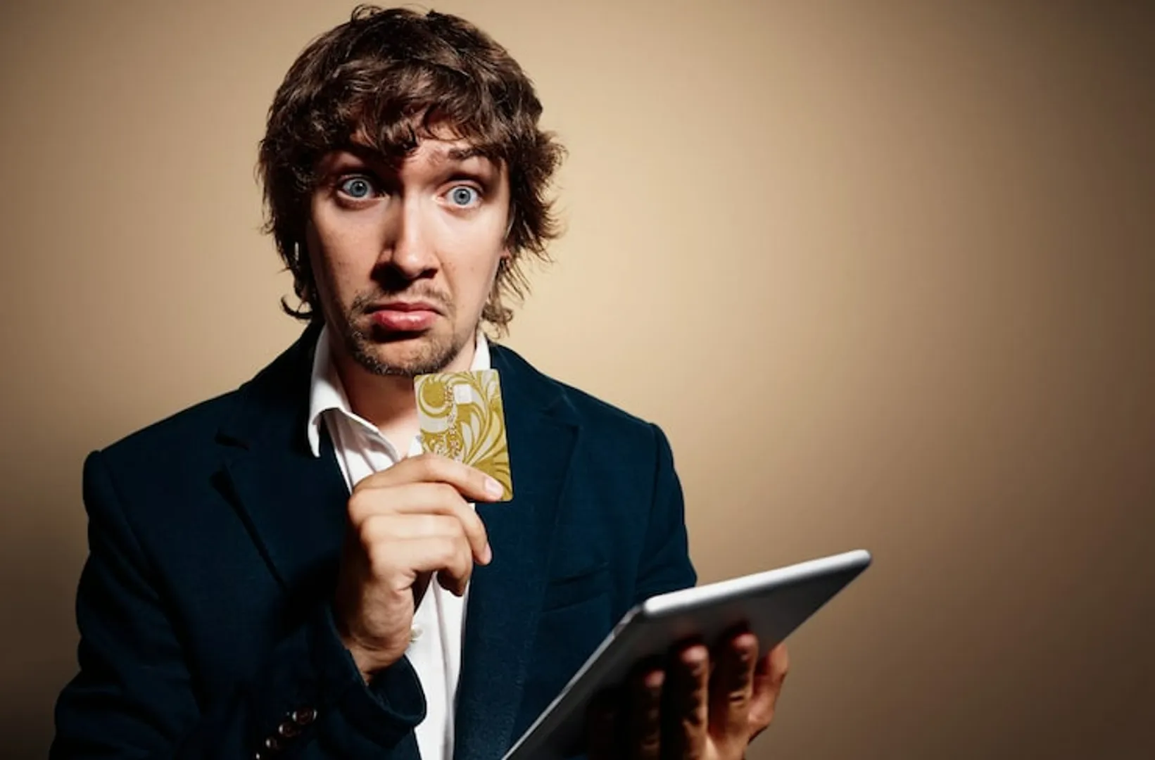 Portrait of young man wearing formal clothes and holding tablet