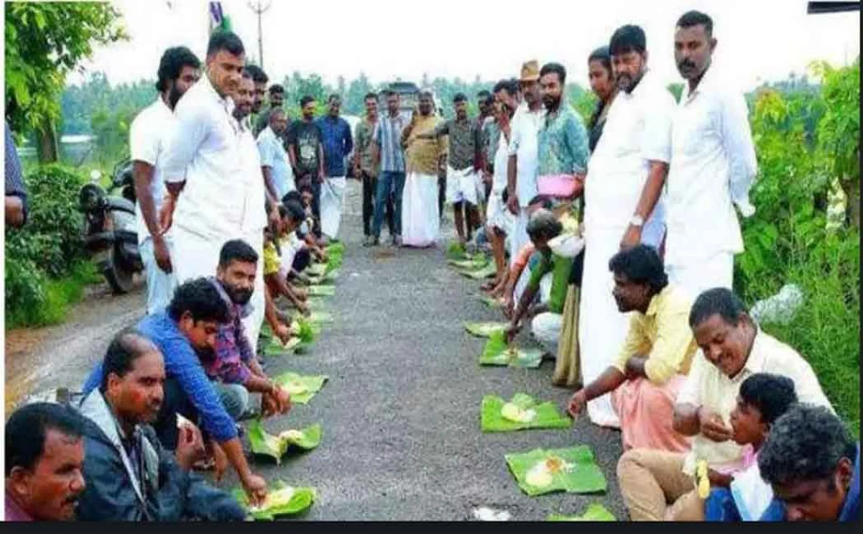 kerala congress party members  sitting on the road eating in celebrating the onam festival 