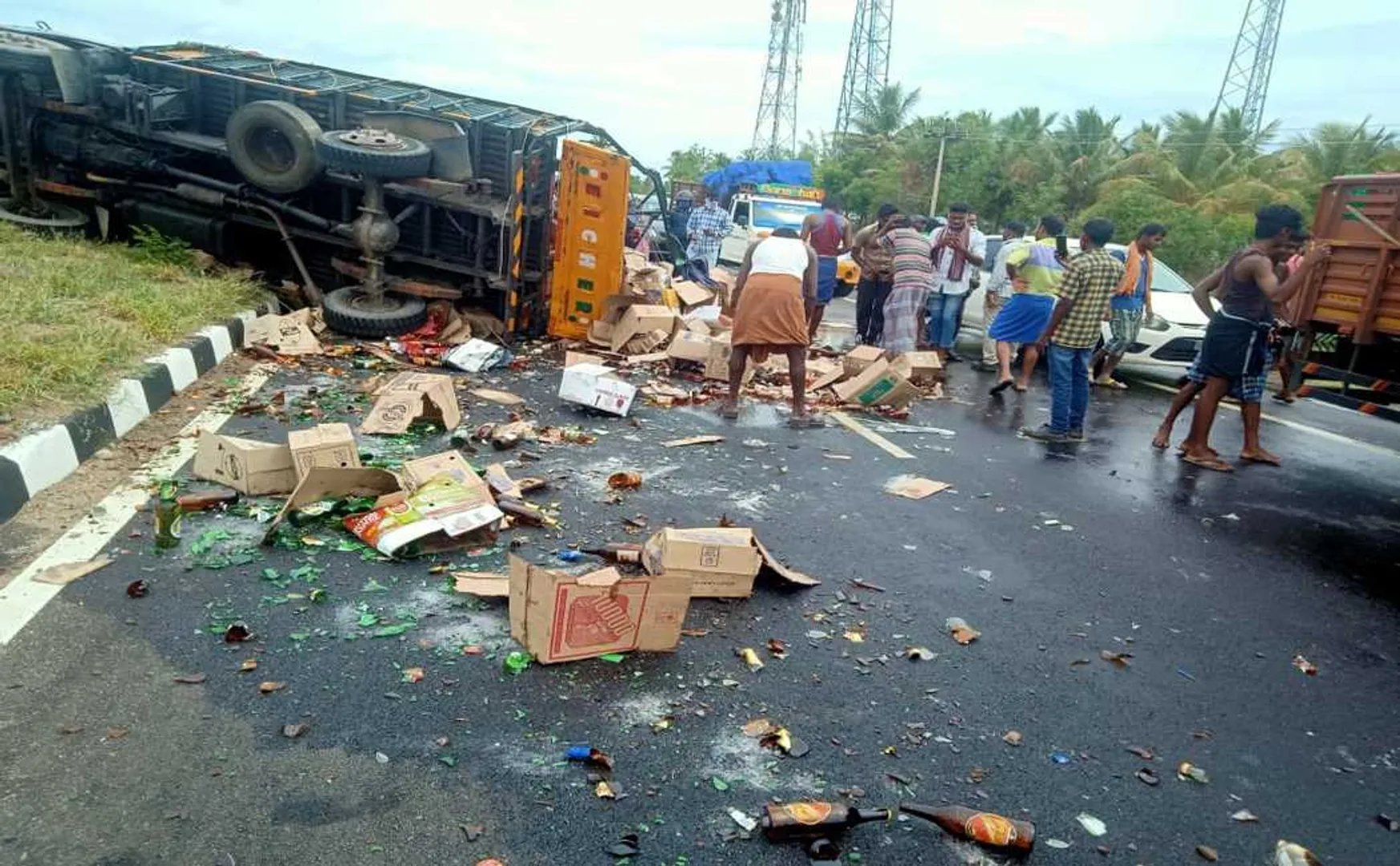 truck carrying liquor met with an accident and people taking away the liquor bottles