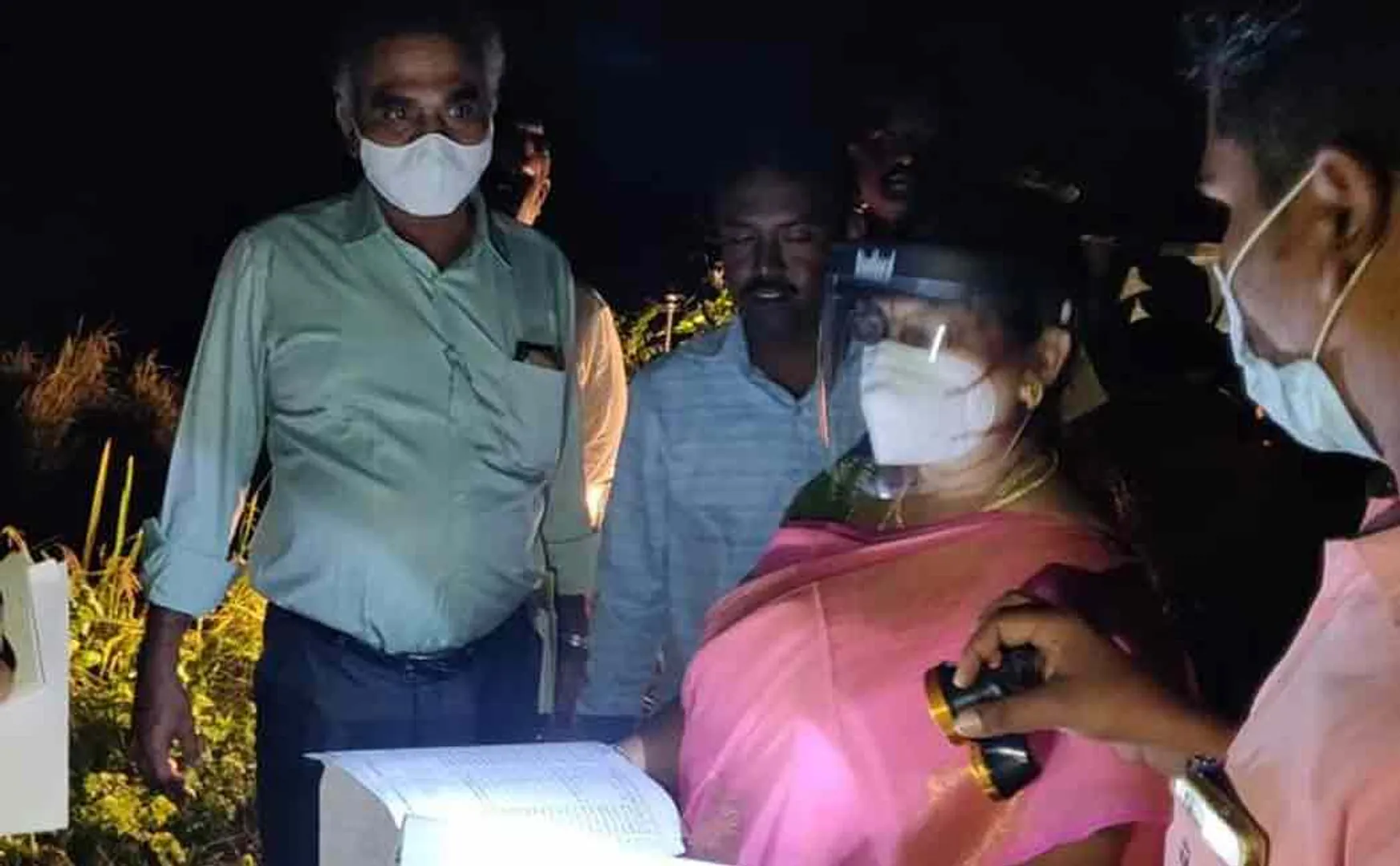 Officials inspect rain flood damage by torch light ...