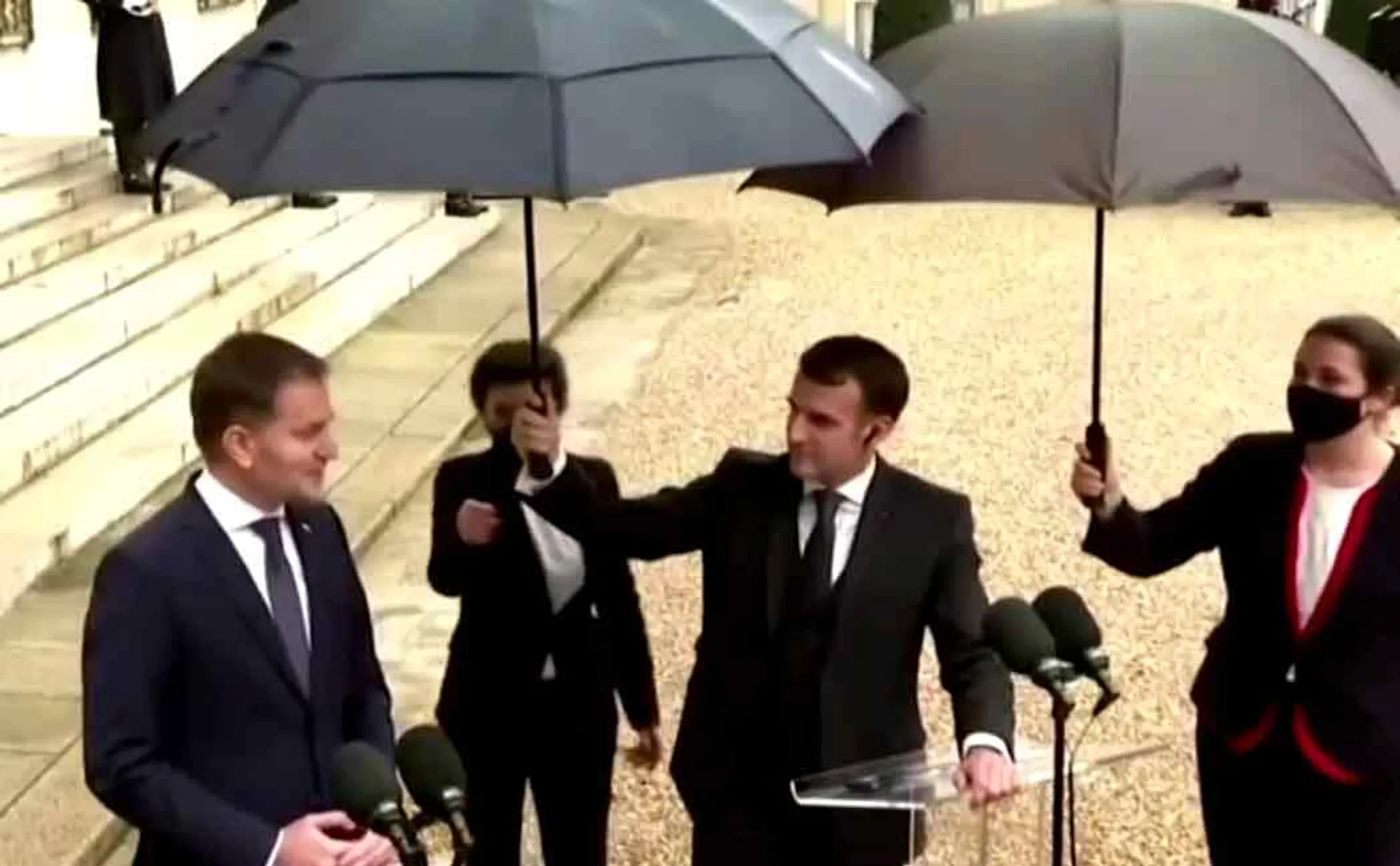 french president holds umbrella for Slovakia prime minister
