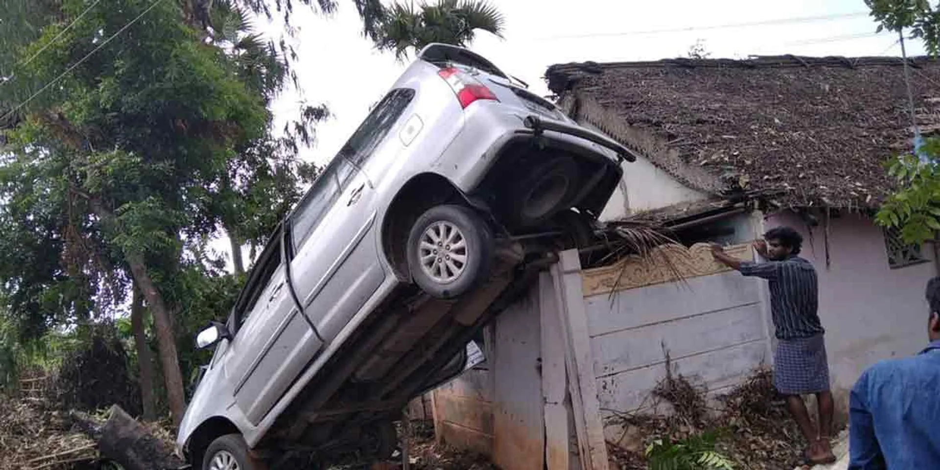 Innova car hanging upside down on the roof of the house!