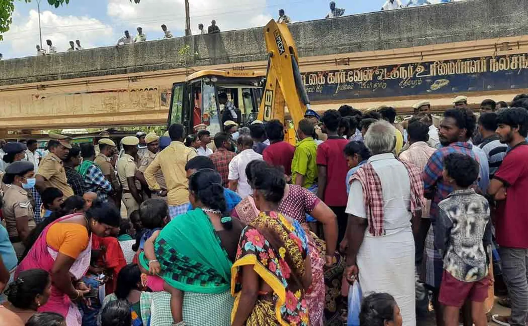 Struggle to block the jcb vehicle that came to demolish houses
