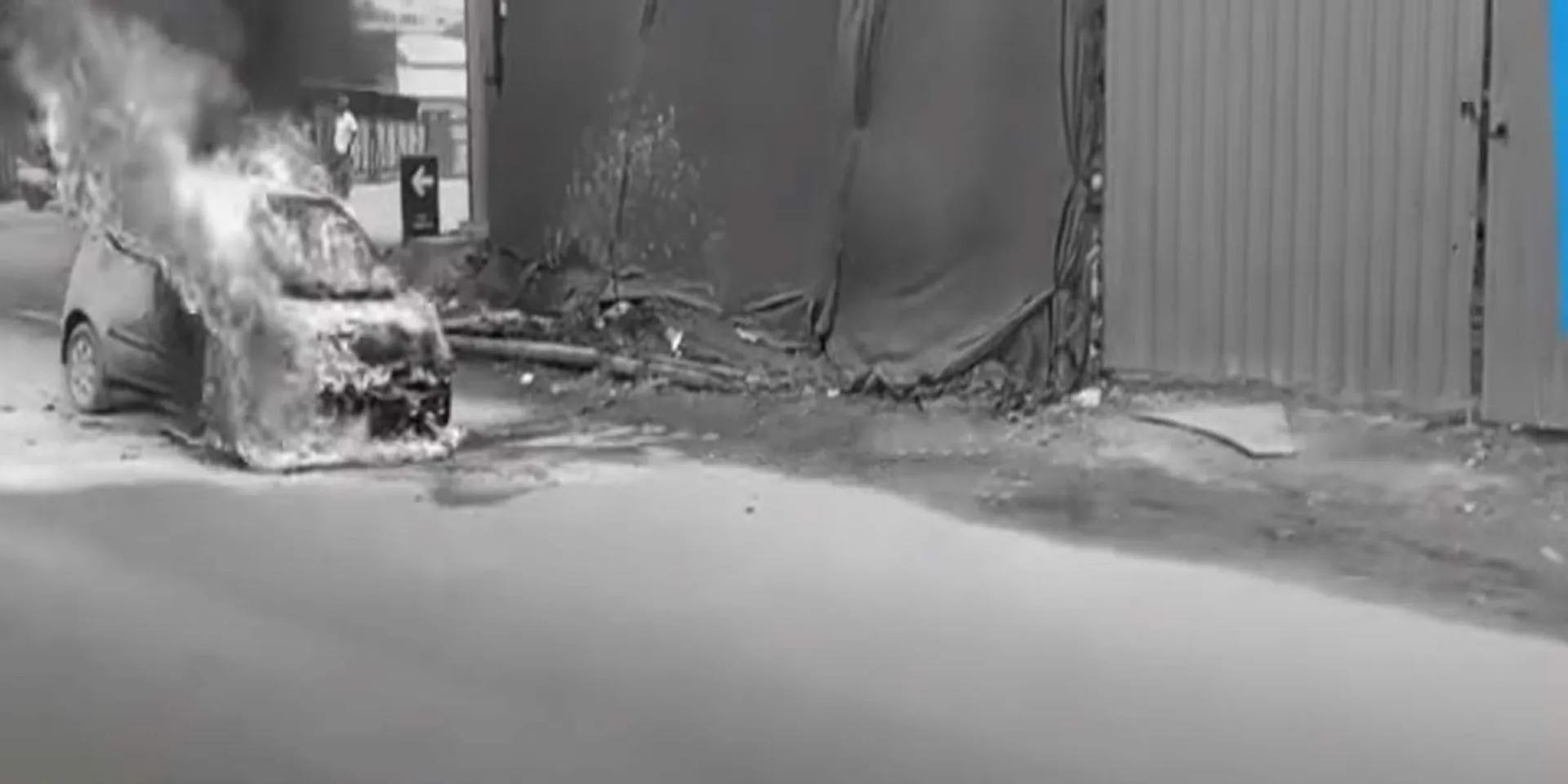 A burnt car about in the middle of the road; incident in Avadi