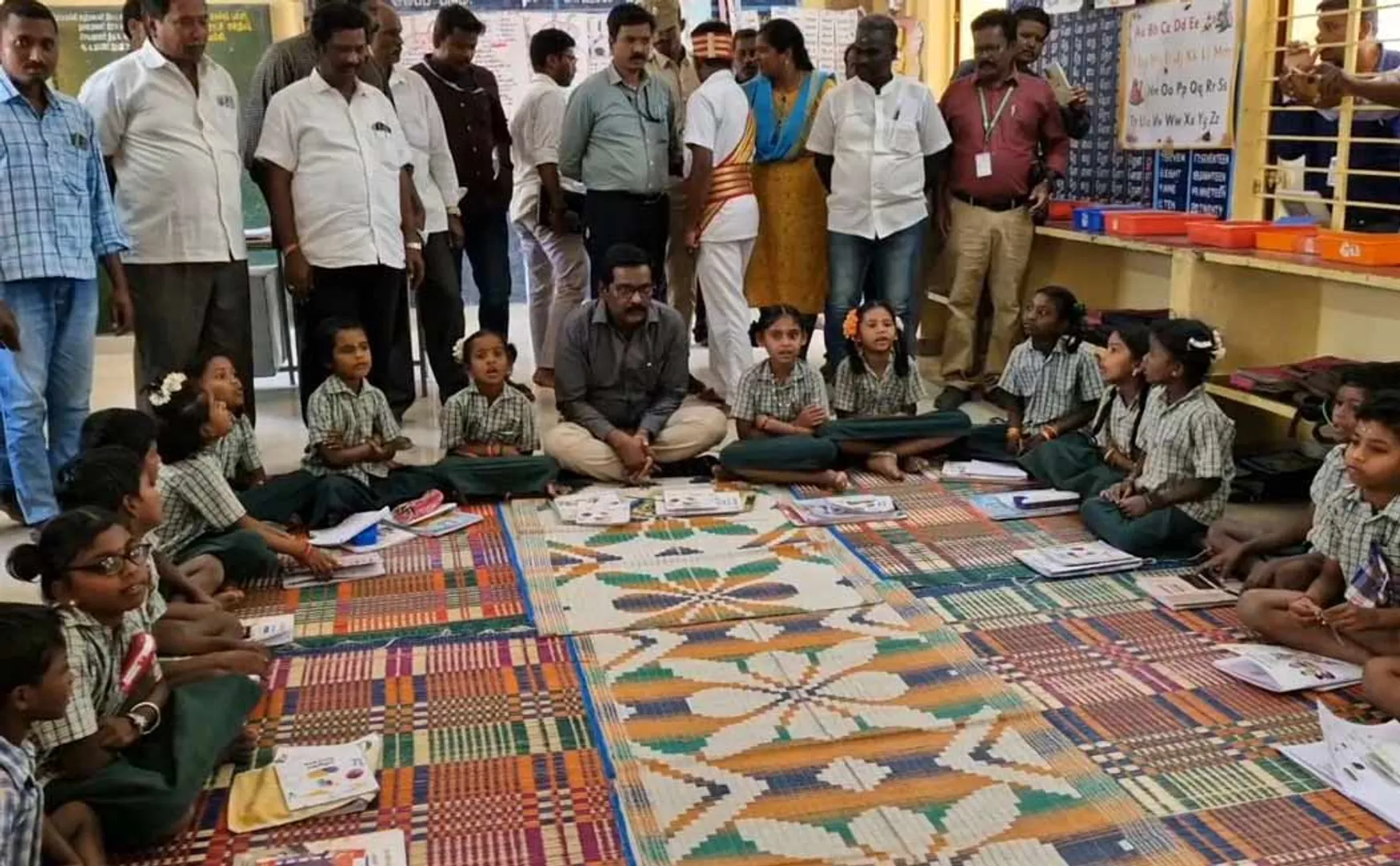 collector sat on the floor and ate the food with the school students