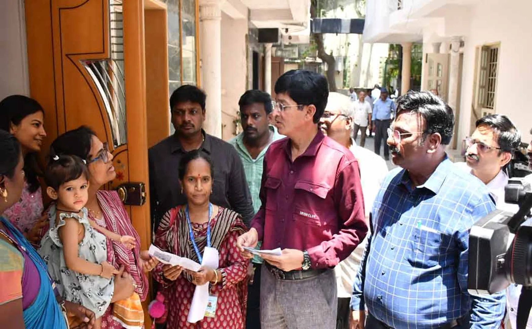 Additional Chief Secretary giving booth slip to voters (pictures)