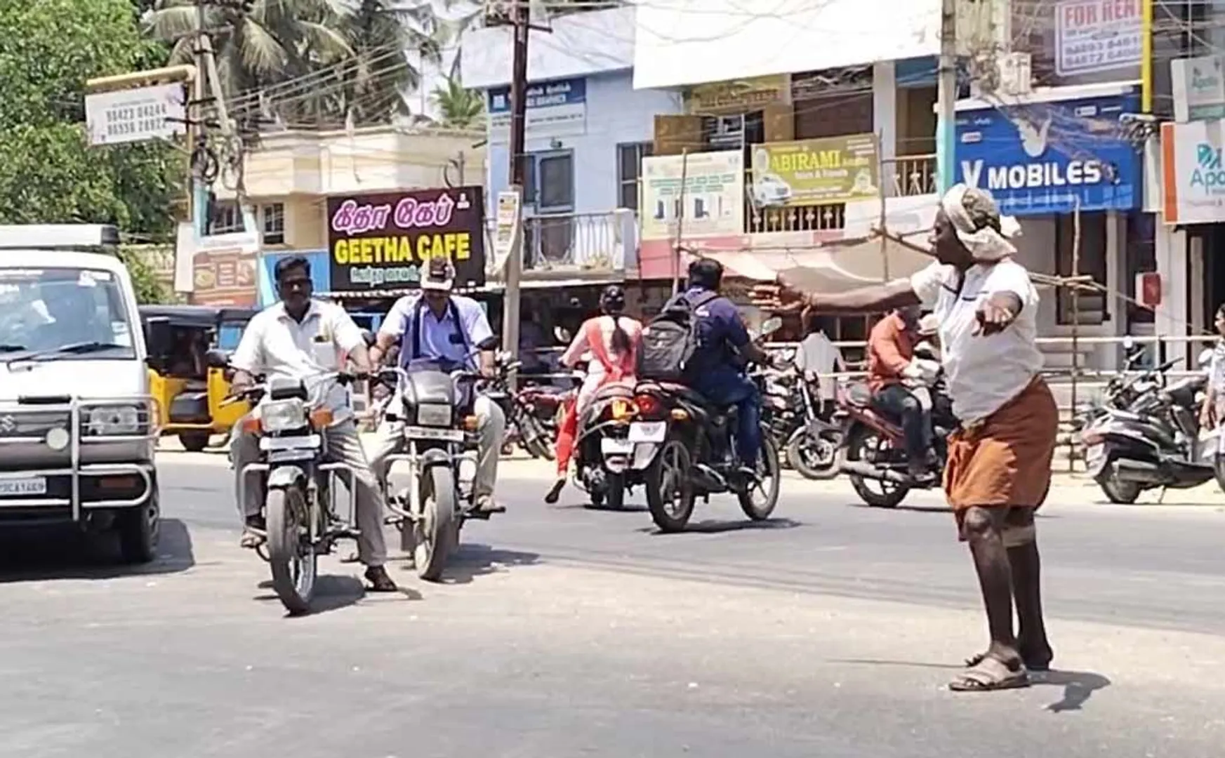  old man fixing the traffic in the hot sun 