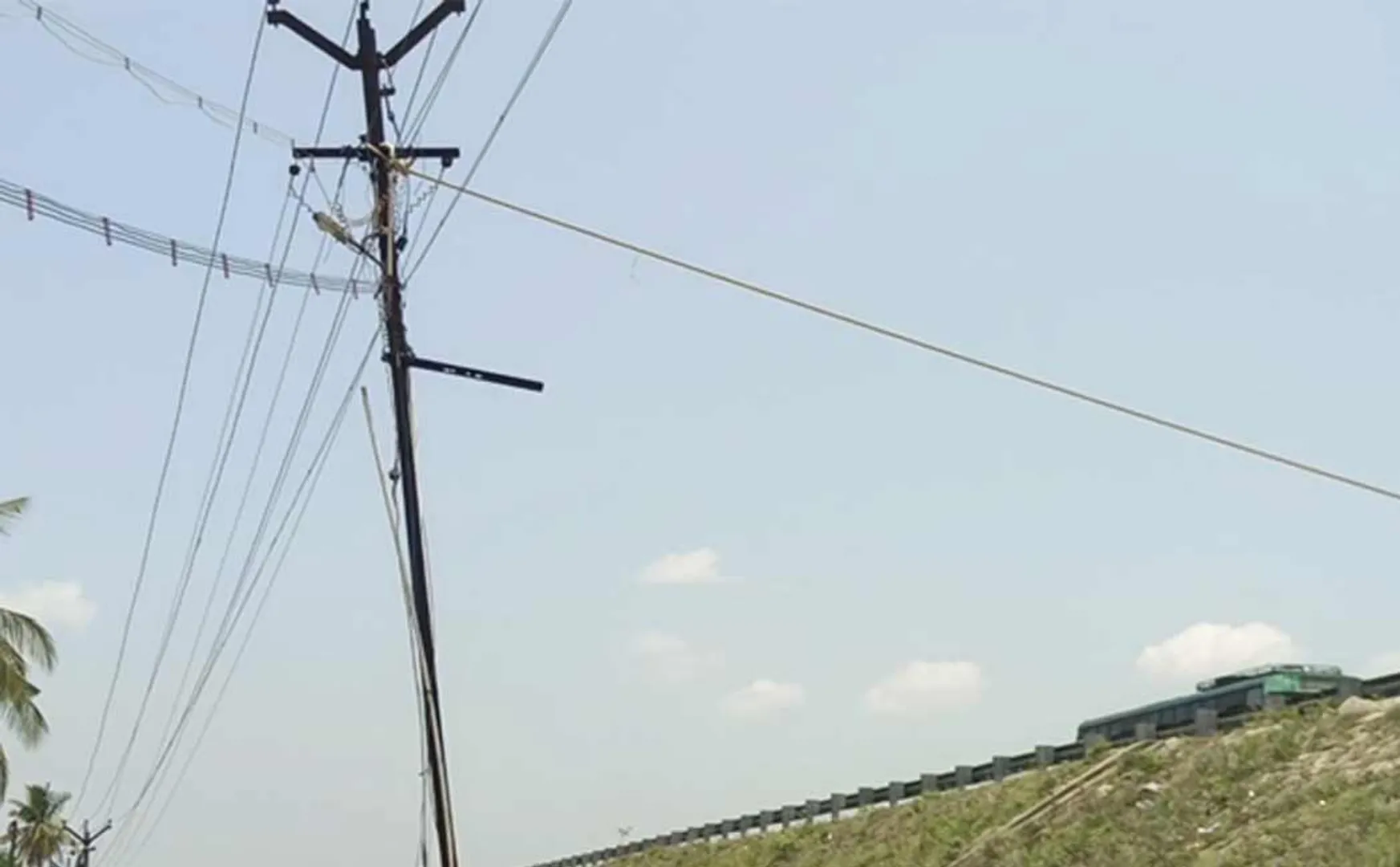 Power workers tied a rope to hold the falling power pole