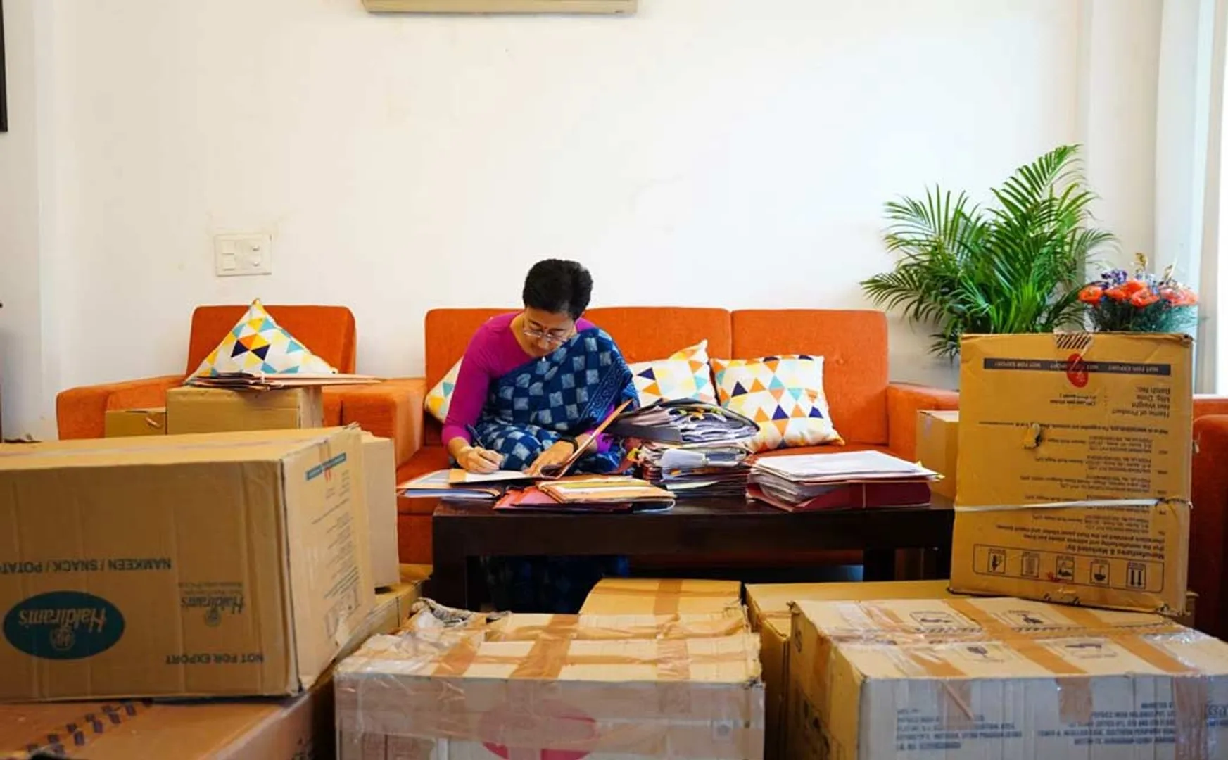 Adishi works sitting among the cartons
