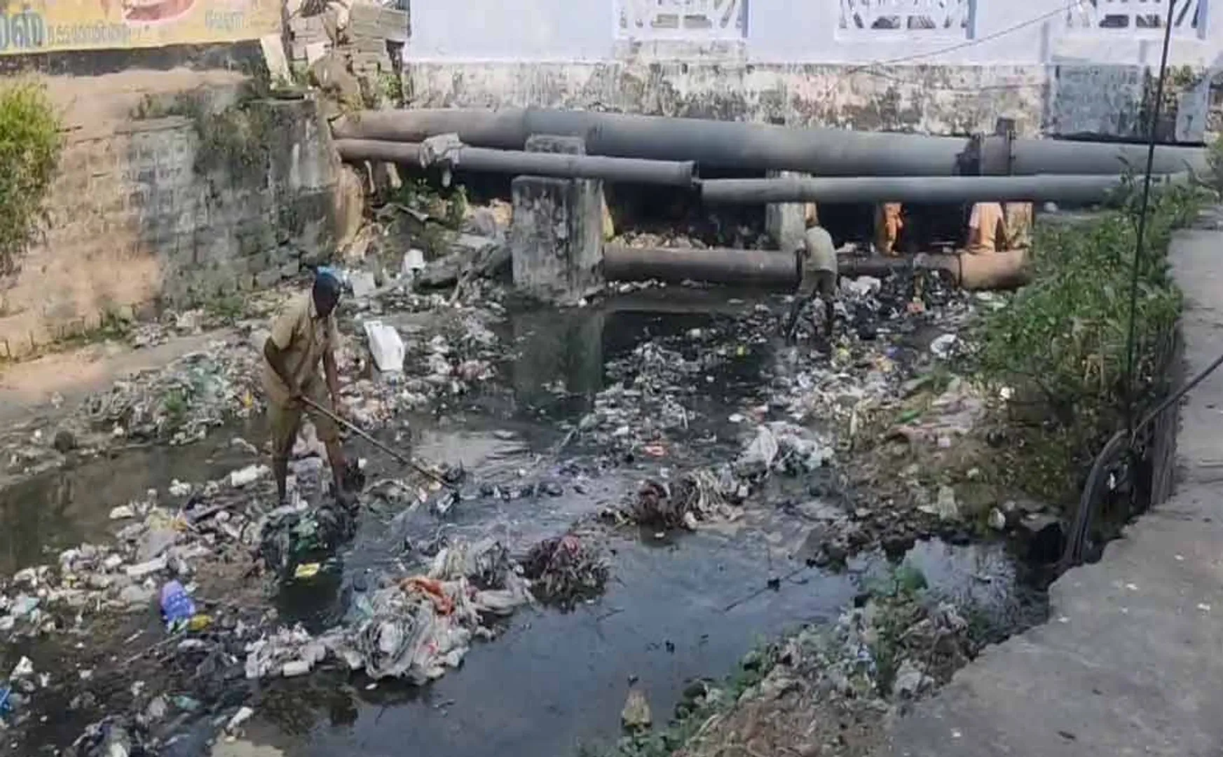 sanitation workers go into the canal to remove garbage without protective equipment in vellore
