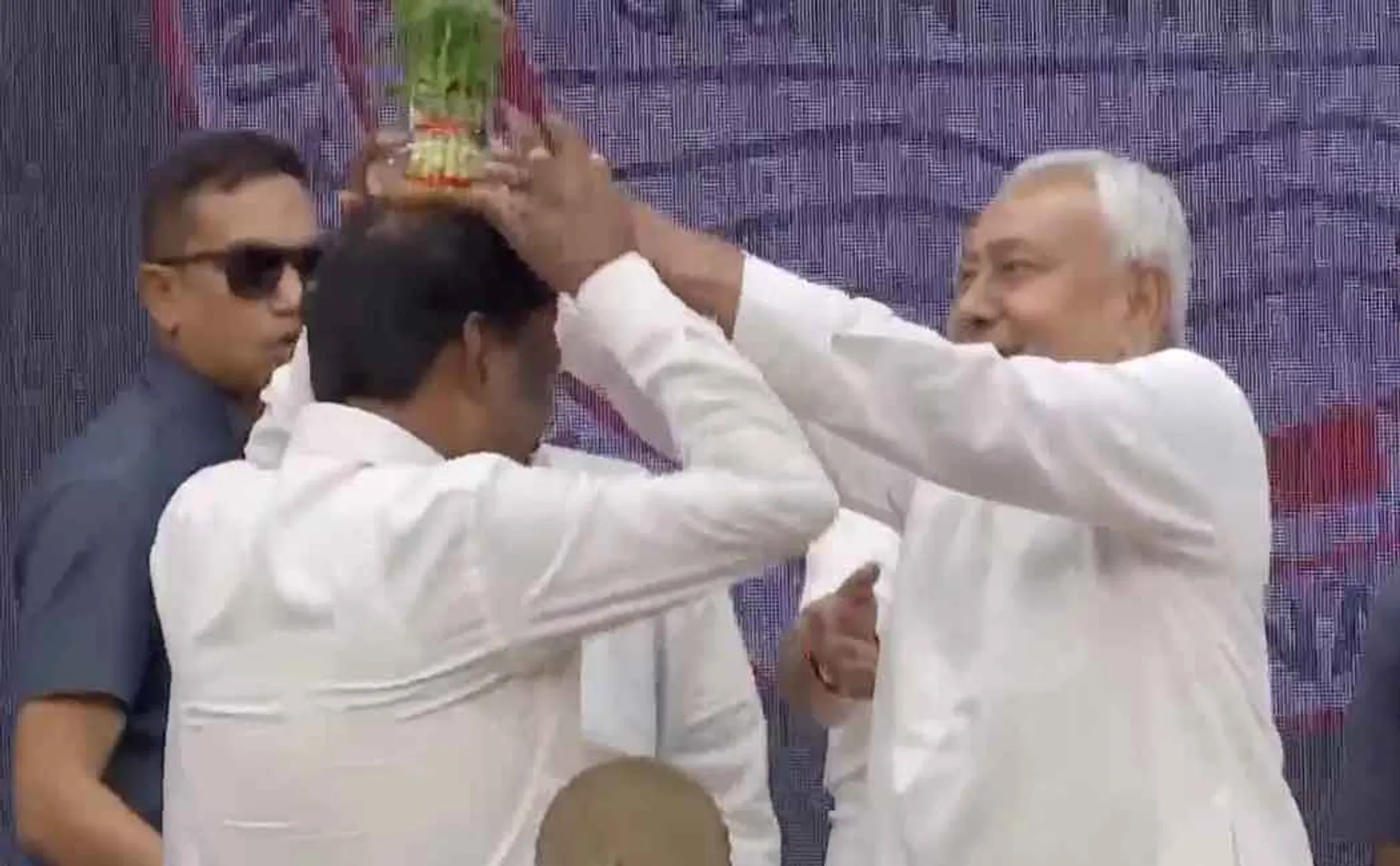 Nitish Kumar places a flower pot on the head of an IAS officer in bihar