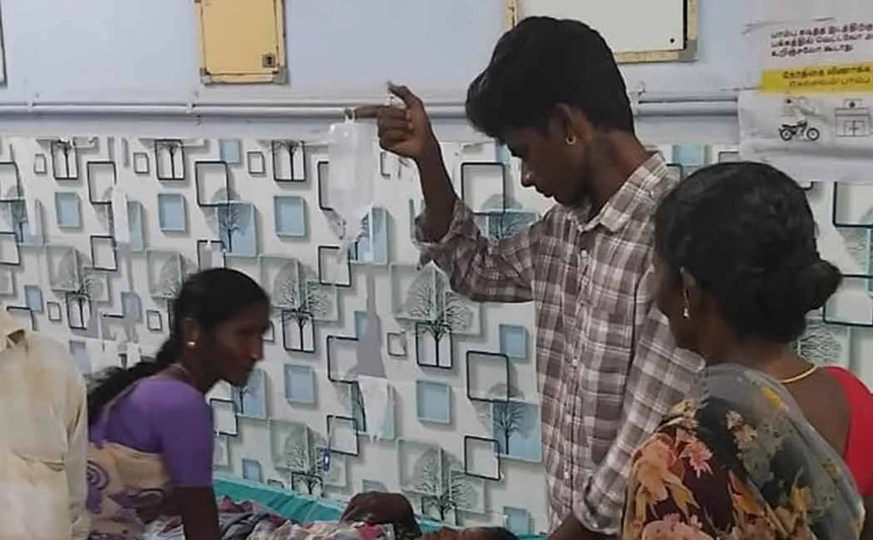 man was holding a glucose bottle in his hand at a government hospital 