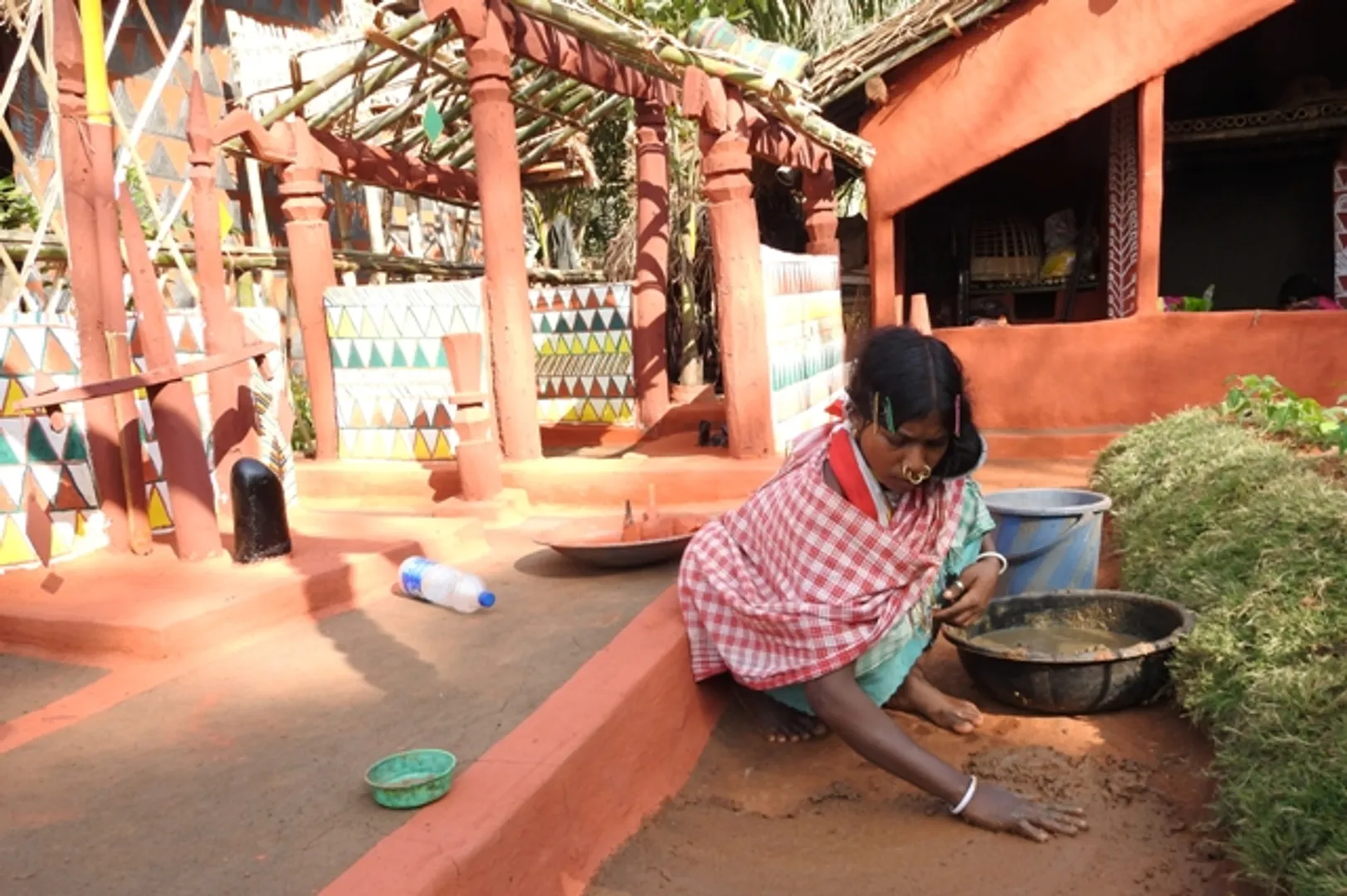 ପ୍ରଦର୍ଶନୀ ପଡ଼ିଆରେ ହେବାକୁ ଥିବା ‘ଆଦିବାସୀ ମେଳା’ରେ ଘର ସଜାଇବାରେ ବ୍ୟସ୍ତ ଜଣେ ଆଦିବାସୀ ମହିଳା। (ଫଟୋ-ବିଭୂତି)