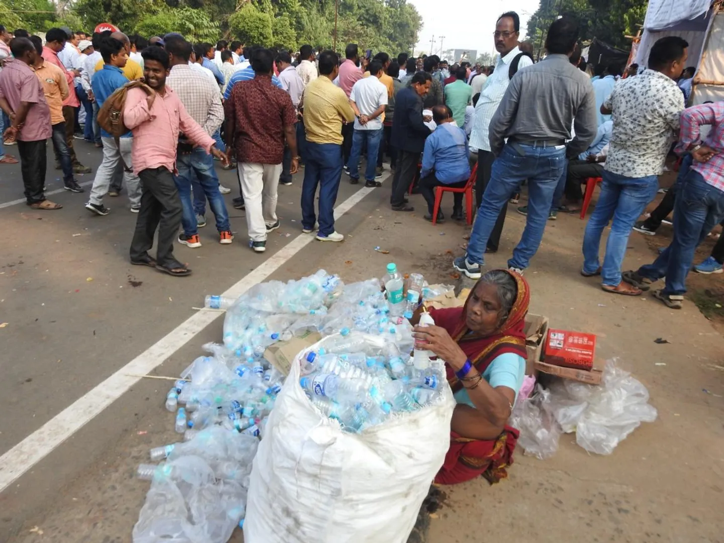 ଜୀବନ ଜୀବିକା: ମହାତ୍ମା ଗାନ୍ଧୀ ମାର୍ଗରେ ପ୍ଲାଷ୍ଟିକ ବୋତଲ ସଂଗ୍ରହ କରୁଛନ୍ତି ଜଣେ ମହିଳା। (ଫଟୋ: ବିଭୂତି)