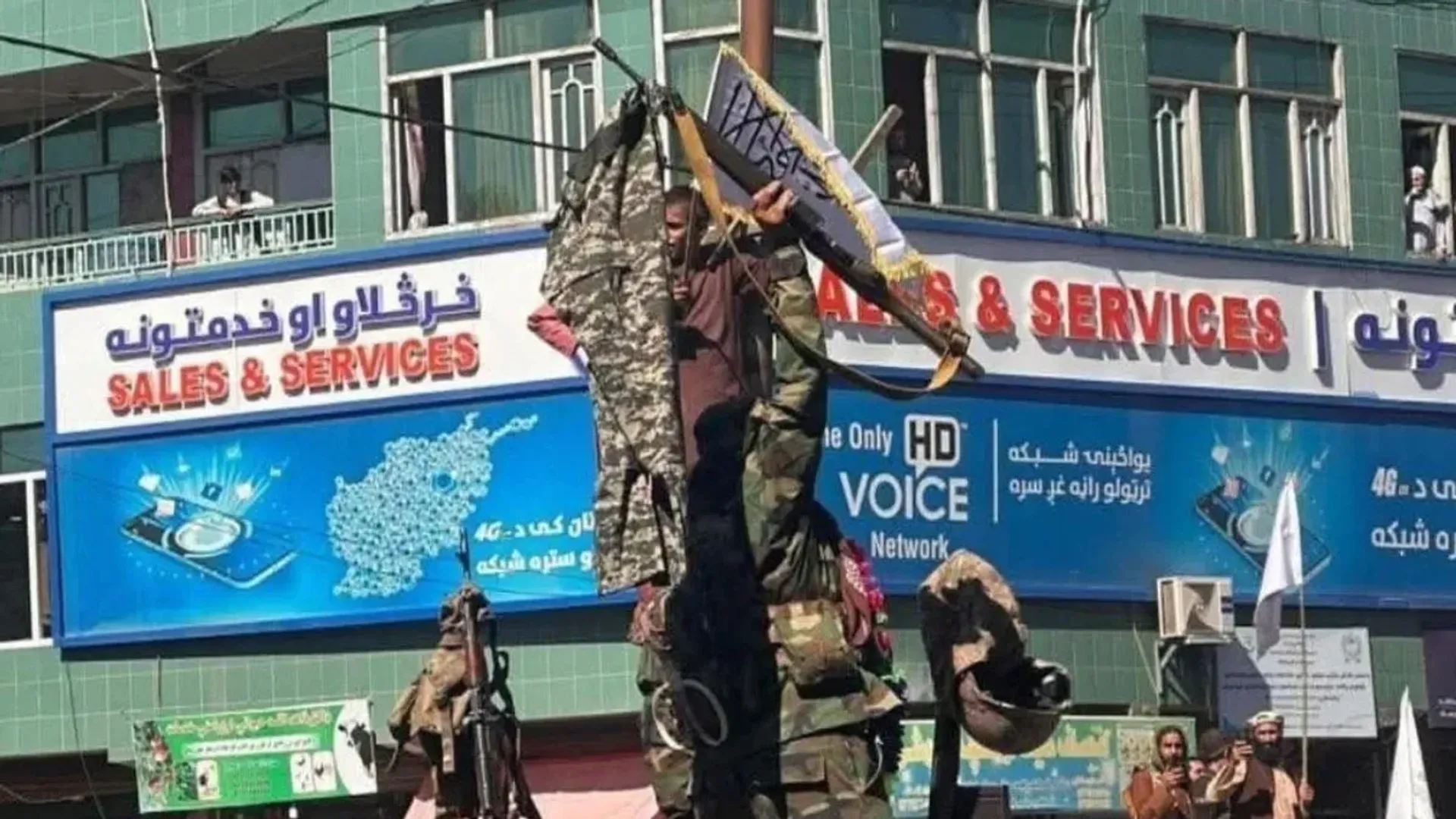  Taliban fighters display pants and weapons of Pak soldiers after a counter-attack post image
