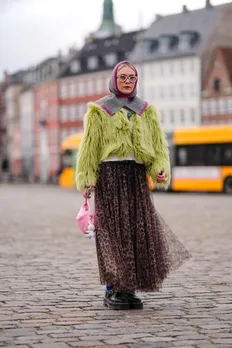 copenhagen, denmark january 31: a guest wears a purple and gray ribbed wool balaclava / hood, a yellow / green fluffy oversized jacket , a flowing tulle leopard print pattern gathered and pleated skirt, blue tights, black leather shoes, a pink bag outside wood wood, during the copenhagen fashion week aw24 on january 31, 2024 in copenhagen, denmark. (photo by edward berthelot/getty images)