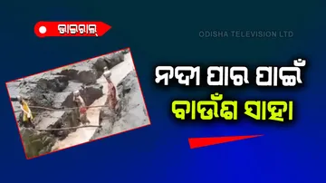 Women crossing river carrying heavy containers on head