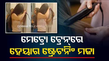 Woman Using Hair straightener inside Delhi Metro