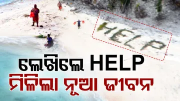 Writing 'HELP' On Beach