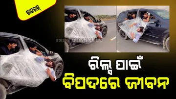 Man hangs from door of moving car in death defying reckless stunt