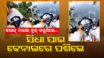 Youth enters into canal with bike