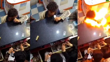 HORRIFYING! Youth bites mobile phone battery, triggers sudden explosion inside shop; watch