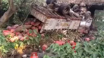 Truck loaded with gas cylinders falls off bridge