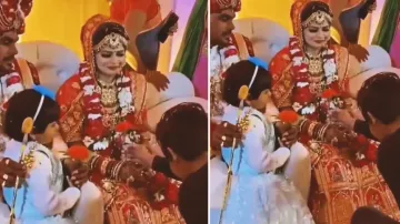 Boy proposes to bride in front of groom on wedding stage