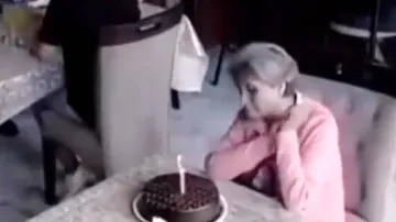 Old lady sitting alone with her birthday cake