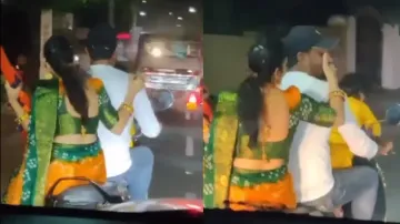 Wife helps hubby to smoke by holding cigarette during scooter ride; watch