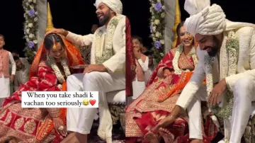 Bride and groom touch each other's feet during wedding rituals