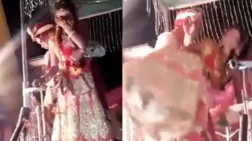Groom falls with bride while trying to lift her in his arm on wedding stage,