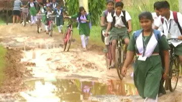 Students and teachers totter on muddy road to 5T school