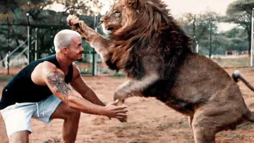 Man and lion share a warm hug