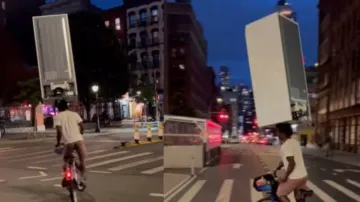  New York man carries fridge on his head while he rides bicycle