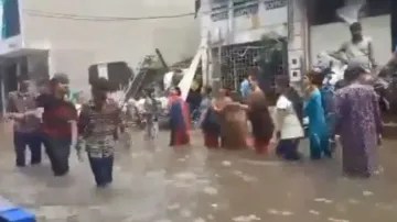 People perform ‘Garba’ on flooded roads amidst the natural disaster
