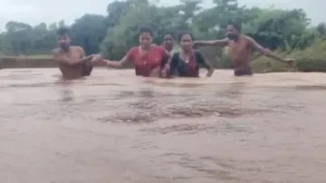 Braving flood water, Anganwadi worker crosses river to reach center in Keonjhar