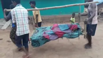 Expectant mother carried on cot, delivers on road