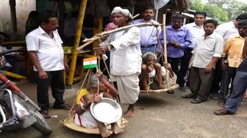 Seeking sympathy, youth carries old-age parents on sling to get justice